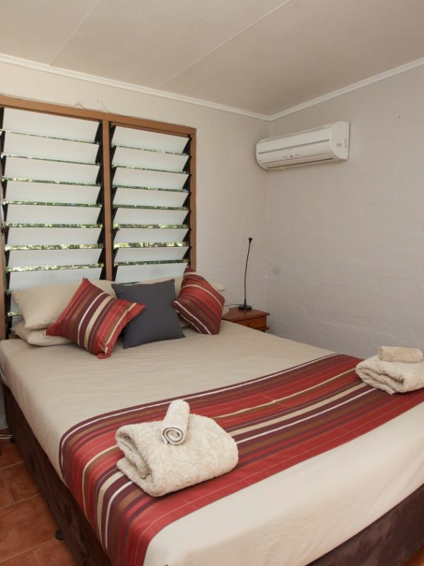 The Skippers Cottage Bedroom that includes an air conditioning unit to keep cool.