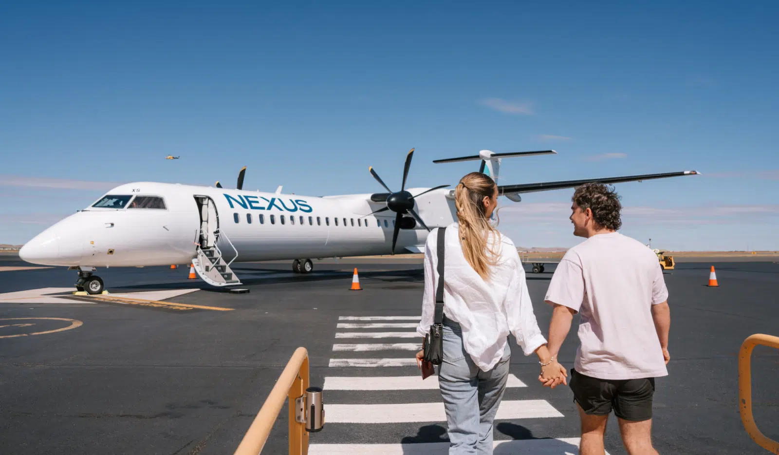 A couple walking on the tarmac towards a Nexus Airlines plane ready to embark on their journey to Broome.